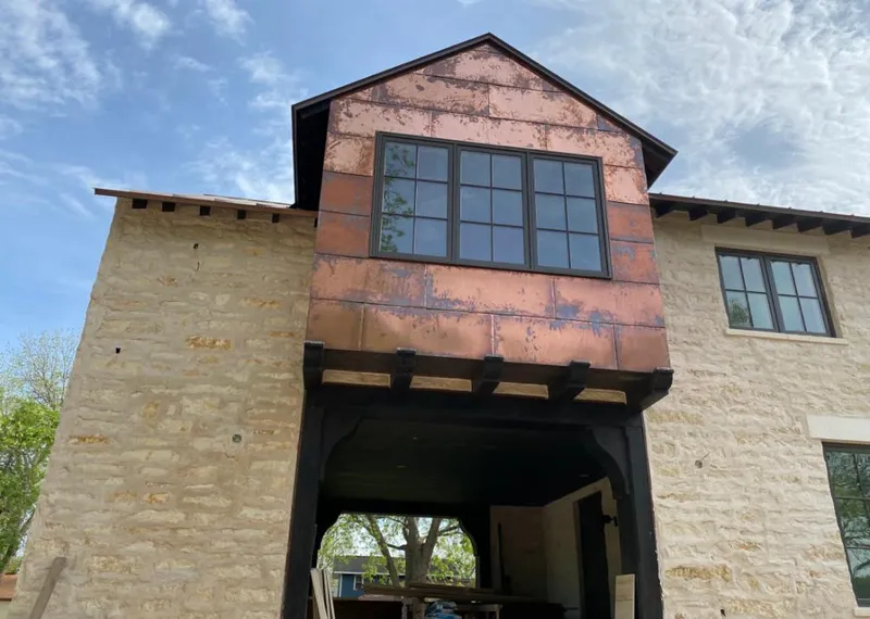 Copper metal panel facade on a stone building for Skylight Installation in Algona